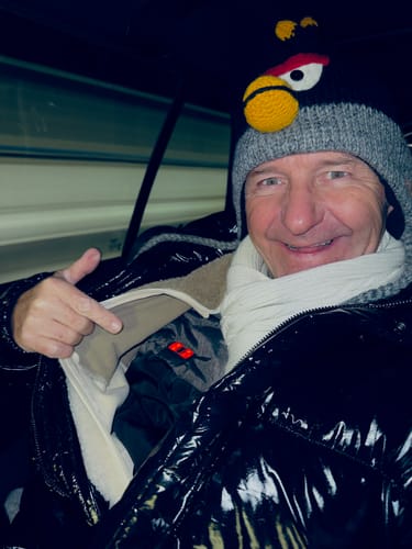 Ein Kunde, der eine glänzende Jacke trägt, zeigt die darunter liegende beheizte Weste.