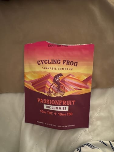 Customer's bag of Passionfruit Gummies resting on a light-colored comforter.