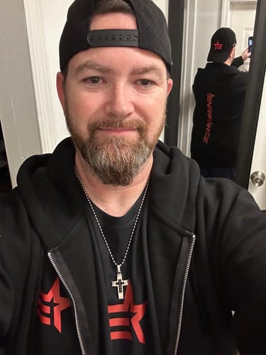Reviewer in an open Rogue Zip Hoodie, using a mirror to show the front and the red vertical graphic on the back.