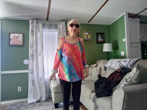 Customer's mother standing in a living room, presented as an 'after' photo from the review.