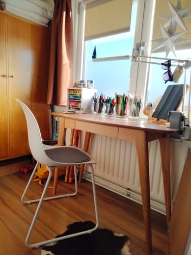 Het eikenhouten Walter Bureau van een klant, ingericht als creatieve werkplek voor een raam.