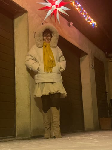 Kunde trägt die Cowboy Stiefel Sierra draußen im Schnee zu einem Rock und einer dicken Winterjacke.