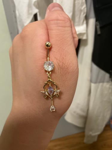 Customer holding the Rising Goddess Belly Dangle to show the gold-plated vintage setting and gems.