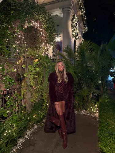 Customer wearing the Burnout Print Turtleneck Romper, styled with a matching long coat and high boots outdoors.