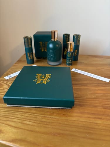 Customer's fragrance collection, including Lady Marmalade, laid out on a table in its green and gold packaging.