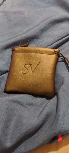 Cliente muestra el empaque de la Cadena Cuban Link, un estuche negro con el logo "SV" sobre una tela azul.