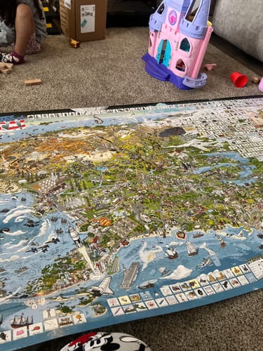 Customer's large World's Greatest Search & Discover poster spread out on a carpeted floor in a home.