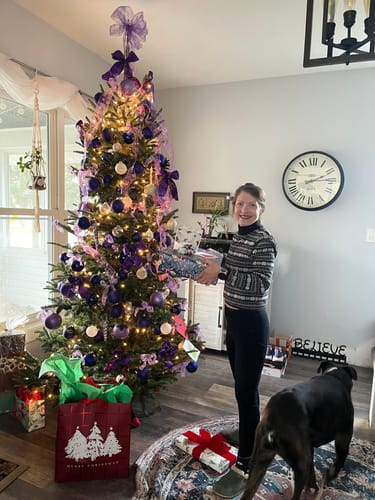 Reviewer showing the petite fit of the dark Piper Pocket Petite leggings in a festive living room.