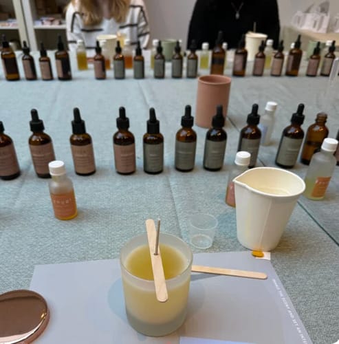 Customer's freshly made candle at the Candle Making Workshop, with various essential oil bottles on the table.