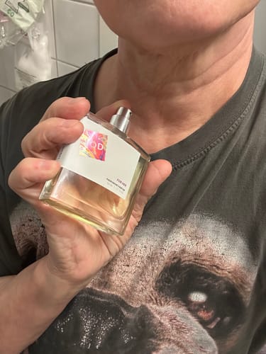 Customer holding a large, clear bottle of For Her V1 Pheromone Perfume.