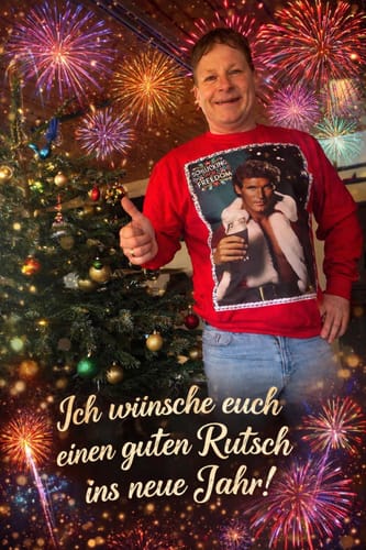 Kunde trägt den roten SCHLUCKING FOR FREEDOM Sweater neben einem Weihnachtsbaum und gibt einen Daumen hoch.