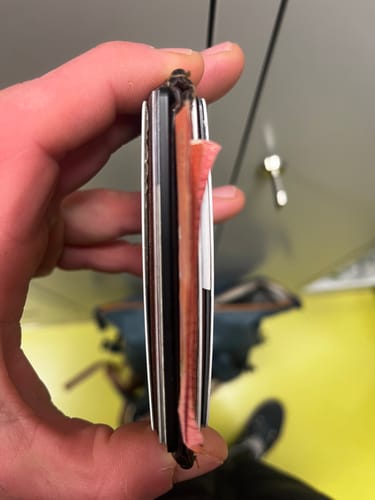 Customer holding a wallet on its side, showing the thickness of the stacked cards inside.