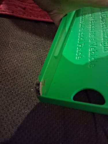 Reviewer's close-up of the green Clean-Up Buddy, showing a chipped corner as mentioned in the review.