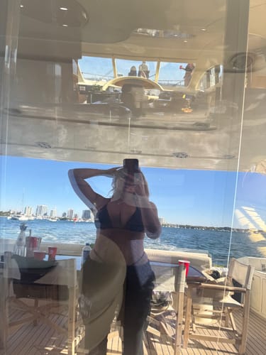 Partial view: Reviewer in a reflection on a boat, wearing what appears to be the Ivy Swim Bottoms.
