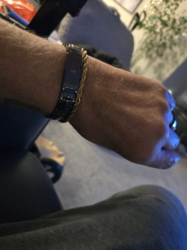 A customer wears the Lord's Prayer Magnetic Copper Bracelet on their wrist, showing its dark links and center plaque.