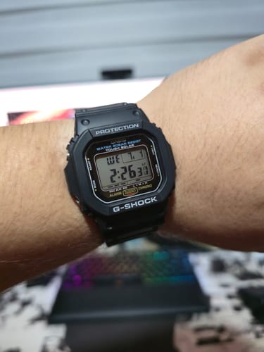 Cliente usando su reloj negro Casio G-Shock G-5600UE-1JF en la muñeca, mostrando la esfera digital.