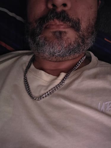 Primer plano de un cliente que lleva la Cadena Cuban Link de 8 mm alrededor del cuello.