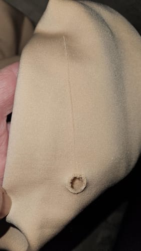 Avis du client : gros plan sur un trou et une maille filée sur le collant polaire beige.