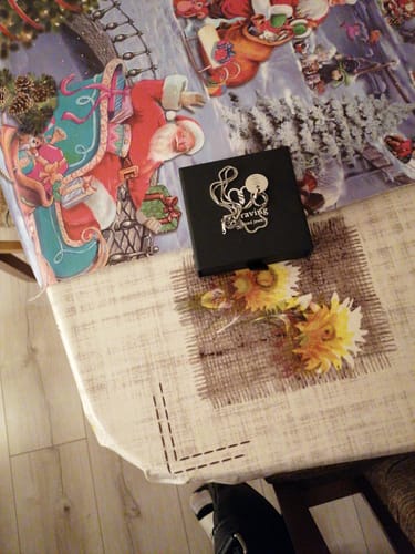 Customer's black jewelry box for their Hug Ring, displayed on a holiday-themed tablecloth.