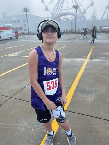 Reviewer wearing John 3:16 The Cross Performance Shorts, pulling up the outer layer to show the cross graphic underneath.