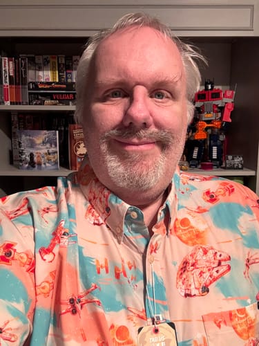 Reviewer wearing the colorful Star Wars™ "Cosmic Crossfire" shirt, showing its orange and teal pattern with the Millennium Falcon.