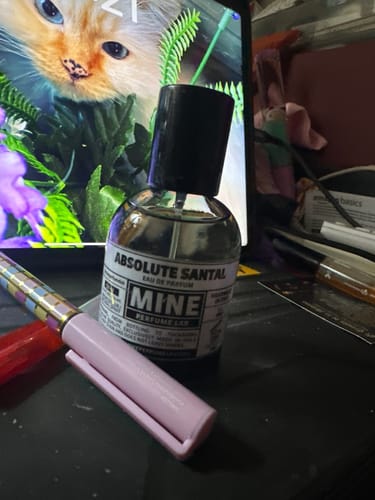 Flacone del profumo ABSOLUTE SANTAL di un cliente su una scrivania.