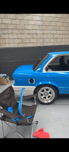 Partial view of a car's rear quarter panel covered in the VViViD+ Gloss Smurf Blue vinyl wrap.