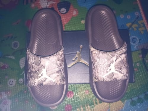 Customer's pair of Jordan Franchise Slides with grey patterned straps, displayed on top of the box.