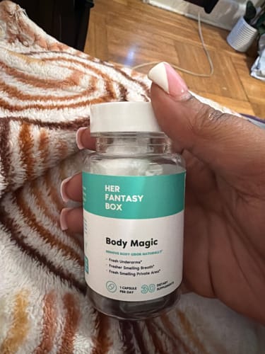 Reviewer holding a clear bottle of Body Magic Chlorophyll Pills, showing the front label.