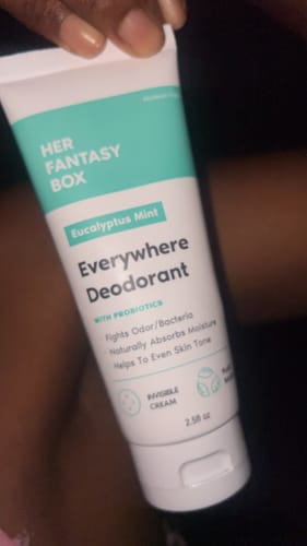 Customer holding the white and mint-green tube of Everywhere Deodorant (Eucalyptus Mint).