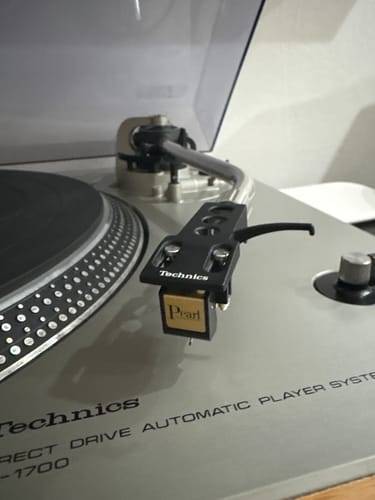 Customer's black Sumiko Pearl Phono Cartridge with a gold front installed on the tonearm of a Technics turntable.