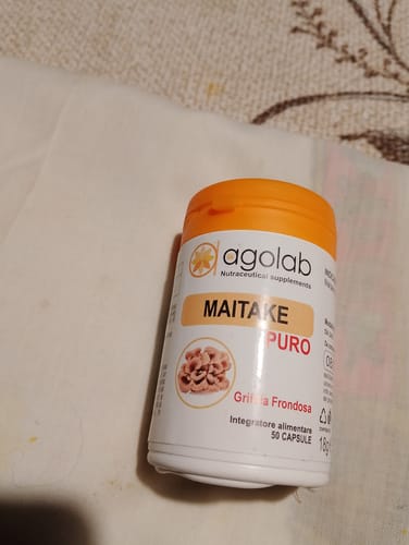 Un cliente mostra il flacone bianco dell'integratore Maitake con il tappo arancione.