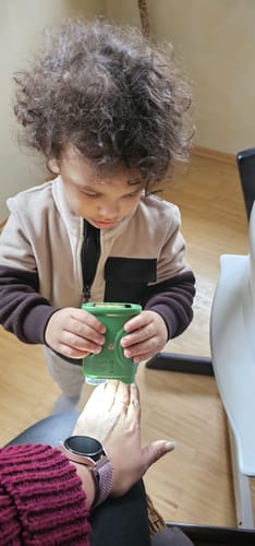 Ein Kind des Rezensenten untersucht eine Hand mit dem grünen Abenteuer-Mikroskop.