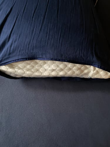 Anmelders ComfortPillow 2.0 med sit vatterede betræk, der kigger frem fra et mørkeblåt pudebetræk.
