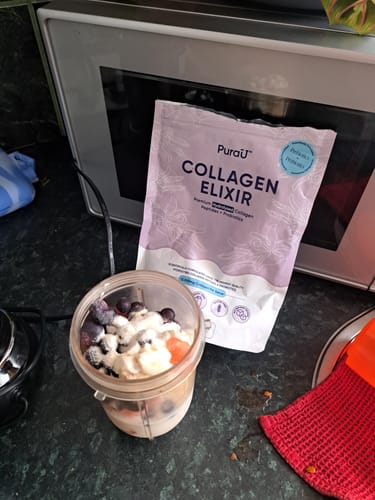 Reviewer's pouch of Collagen Renew™ on a kitchen counter next to a blender cup with fruit.