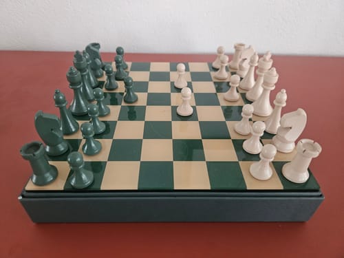 Recensent toont het opgestelde Printworks Classic schaakbord, met de groene en beige schaakstukken.