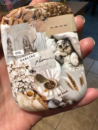 Customer holding the Darlin' ChargePod, which has a cute collage design featuring a cat, text, and flowers.