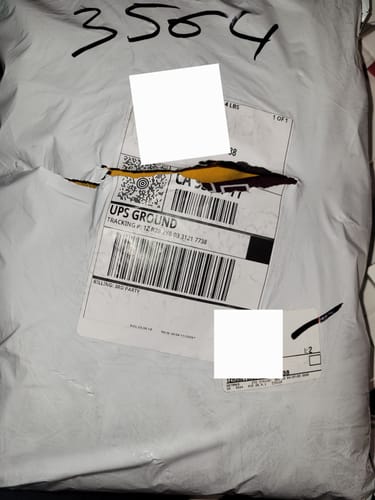 Reviewer shows the torn shipping mailer for their Christmas They Not Like Us Hoodie.