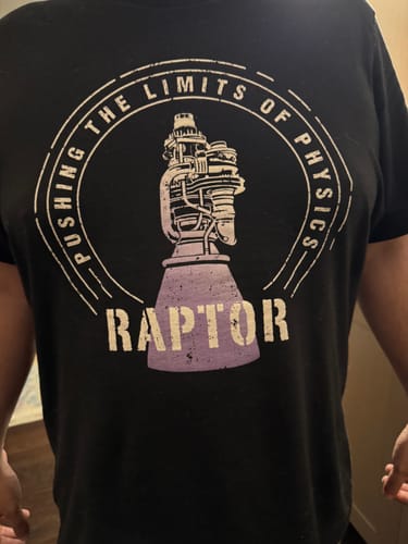Close-up of a customer wearing a black graphic t-shirt with a Raptor engine design.