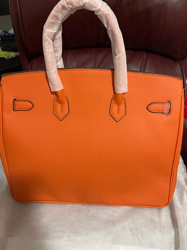 Reviewer's new orange Warkin Bag with plastic-wrapped handles, showing the back view.