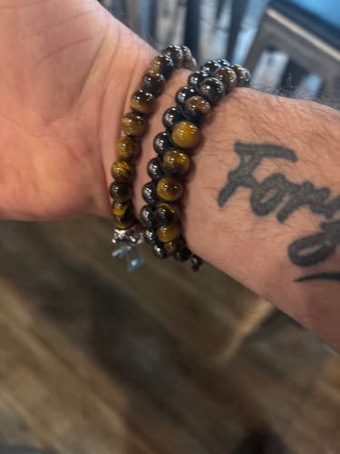 Customer wearing the two-strand Guardian Tiger's Eye Magnetic Bracelet on their tattooed wrist.
