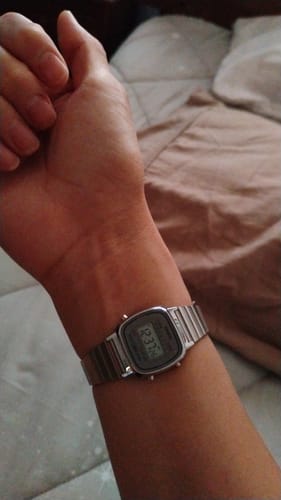 Cliente mostrando su Reloj Casio Vintage plateado en la muñeca, visto de cerca.
