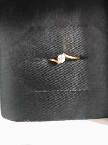 Customer's Golden Splendor Ring with a twisting gold band and central stone in its black box.