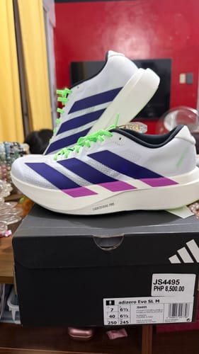 Customer's adidas Adizero EVO SL Running Shoes in white, purple, and lime green, displayed on top of the product box.