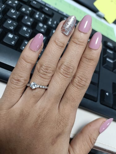 Reviewer's hand wearing the shiny Silver Charm Ring against a keyboard background.
