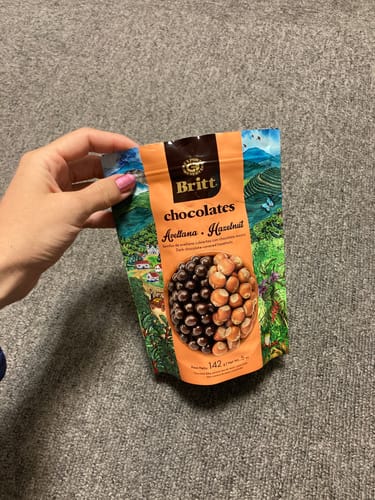 Customer holding the bag of DARK CHOCOLATE COVERED HAZELNUTS.