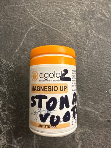 Cliente mostra il flacone di Magnesio UP con la scritta a mano 'Stomaco vuoto' sull'etichetta.