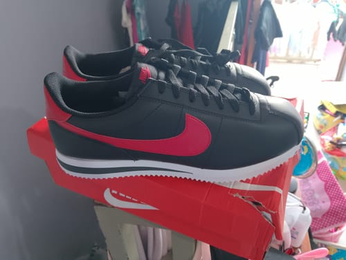Customer's black Nike Cortez Leather Casual Shoes with a red swoosh, displayed on top of the shoebox.