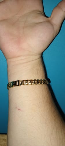 Cliente mostrando el broche seguro de su Pulsera Cuban Oro en la muñeca.