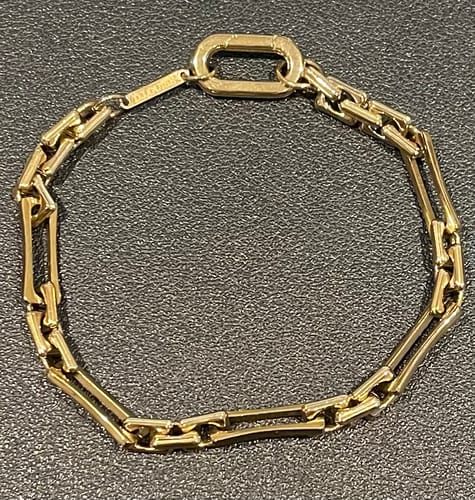 Reviewer's gold Lovers Chain Bracelet laid flat, showing the link design and a small logo bar.